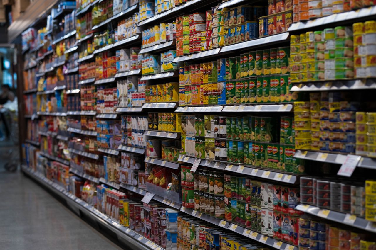 The Art of Drawing Readers In: Your attractive post title goes here A supermarket aisle filled with various canned goods on shelves, showcasing retail diversity.